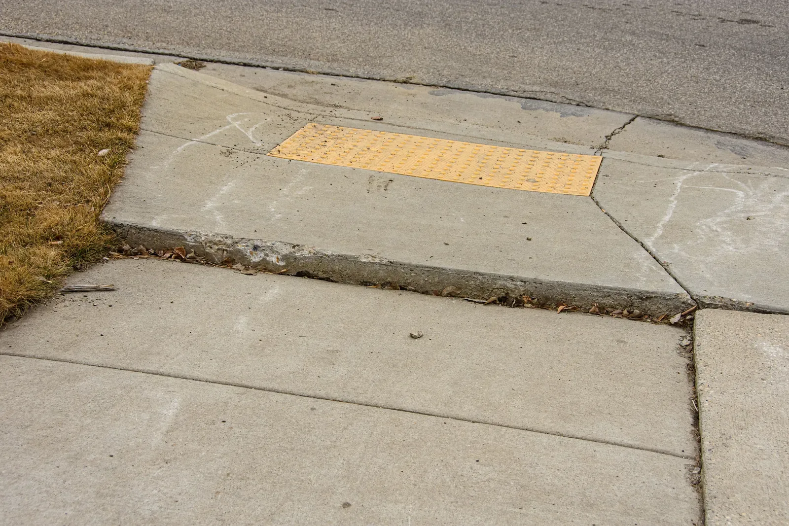 Broken and uneven sidewalk in Pleasant Grove, Utah creating a trip hazard